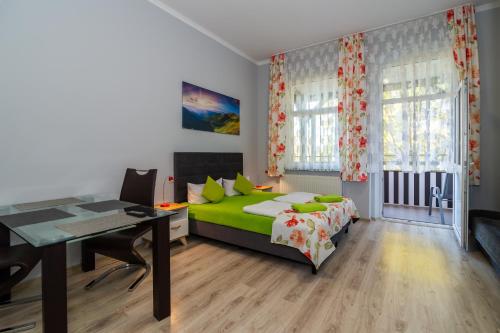 a bedroom with a bed and a desk and a table at Willa Diament in Kudowa-Zdrój