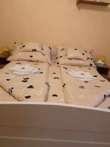 a bed with two pillows on top of it at Natasa Apartman in Orosháza