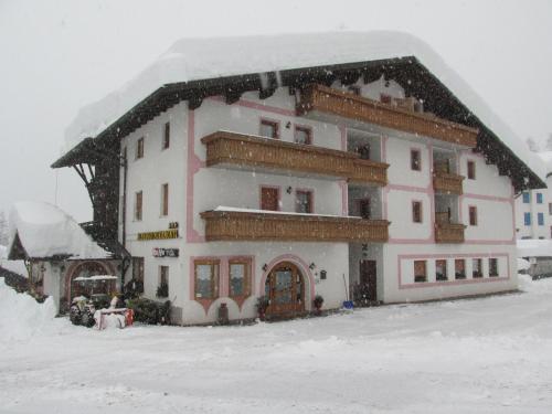 a large building with snow on top of it at Hotel Garnì Miramonti in Falcade