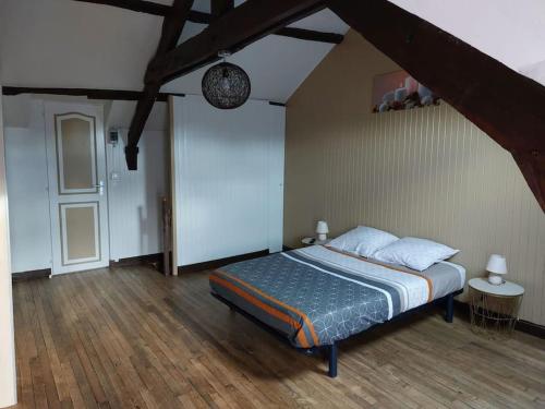 1 dormitorio con 1 cama y suelo de madera en Chez Aurélie et Guillaume, en Guéméné-Penfao