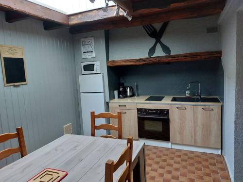 La cuisine est équipée d'une table, d'un évier et d'un réfrigérateur. dans l'établissement Chez Aurélie et Guillaume, à Guéméné-Penfao