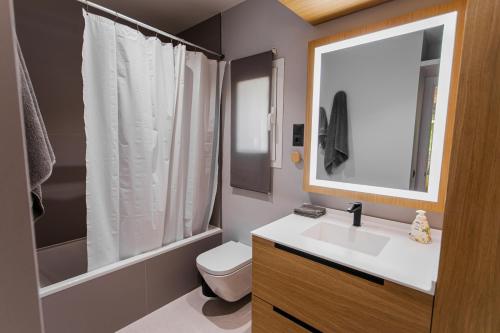 uma casa de banho com um lavatório, um WC e um espelho. em BungaLove em Benalmádena