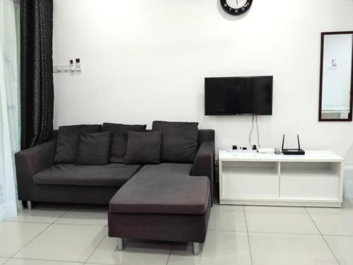 a living room with a couch and a tv at Tapeer Homestay 13CC99 @D Perdana Kota Bharu in Kota Bharu