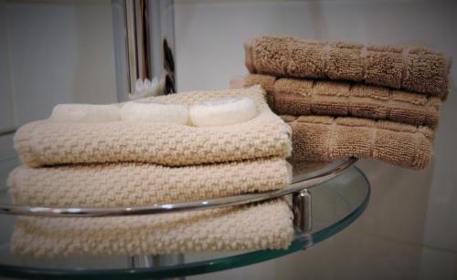 a stack of towels sitting on a glass table at Old Town Warsaw Joanna's Apartments in Warsaw