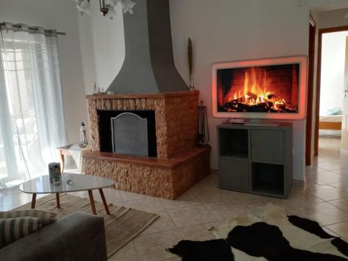 a living room with a fireplace and a tv at The mulberry apartment in Korfos