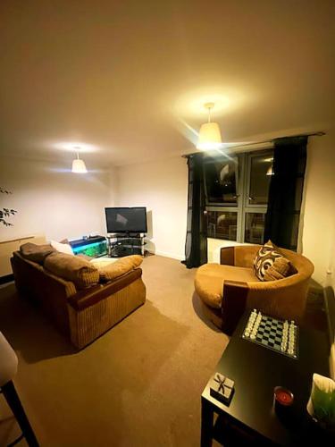 a living room with two couches and a television at Nottingham city view apartment in Nottingham