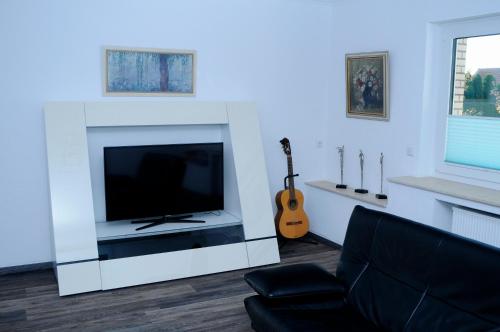 ein Wohnzimmer mit einem TV und einem Kamin in der Unterkunft Bonsai-Ferienwohnung in Bad Laer