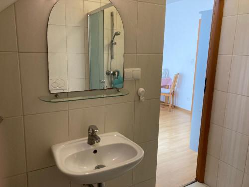 een badkamer met een wastafel en een spiegel aan de muur bij Glada in Jastarnia
