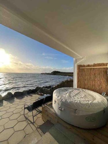 a bed sitting on a platform next to the water at Relax with spectacular views and Hot Tub in Kircubbin