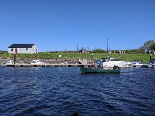 a small boat in the water next to a dock at Killynick Glamping Oiney Fishing County Fermanagh in Enniskillen