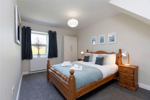 Un dormitorio con una cama grande y una ventana en Auckland View - a comfy & spacious 4bed with views en Coundon