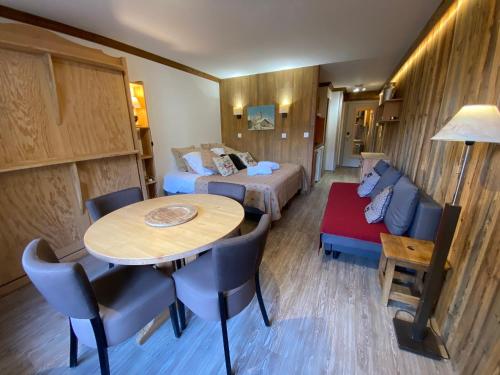 Cette chambre comprend une table, un lit et un canapé. dans l'établissement Résidence CHALET DE SOLAISE - Studio 30 m2 - by MONTBLANC LODGE, à Val dʼIsère