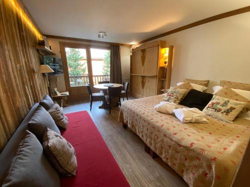 a hotel room with a bed and a couch at RESIDENCE CHALET DE SOLAISE - Studio - 30 m2 in Val-d'Isère