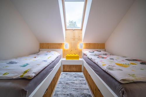 2 camas en una habitación con 2 ventanas en Holiday House U Hájenky 7L Lipno Home, en Lipno nad Vltavou