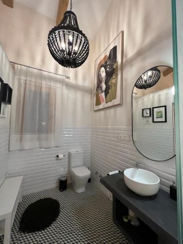 a bathroom with a sink and a toilet and a mirror at La Encantada 2 in Elche de la Sierra
