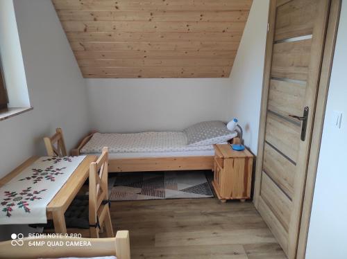 a small room with a bed and a table at Domki Pod Brzyzkiem in Ochotnica Dolna