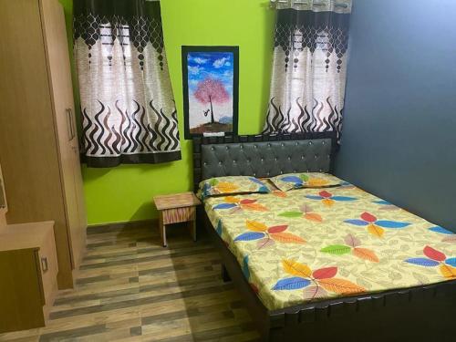 a bedroom with a bed in a room with green walls at Ghar-fully furnished house with 2 Bedroom hall and kitchen in Bengaluru