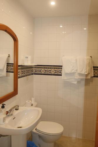 y baño con lavabo, aseo y espejo. en HOSTAL MONCADA en Gaucín