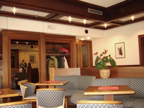 a restaurant with tables and chairs in a room at Hotel Garnì Miramonti in Falcade