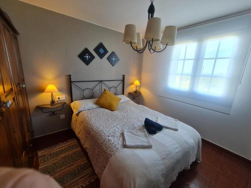 a bedroom with a bed with yellow pillows and a window at apartamento Tita in Tapia de Casariego