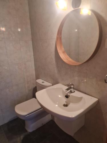 a bathroom with a sink and a toilet and a mirror at apartamento Tita in Tapia de Casariego