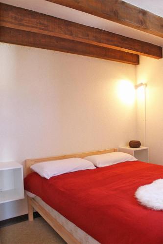 - une chambre avec un lit rouge et des oreillers blancs dans l'établissement Duplex sur le lac Les Angles 7 personnes, aux Angles