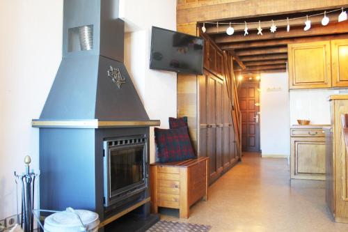 ein Wohnzimmer mit einem Kamin und einem TV in der Unterkunft Duplex sur le lac Les Angles 7 personnes in Les Angles