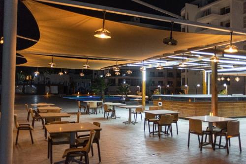 un restaurante con mesas y sillas y un bar en The Comfortable palace en Hurghada