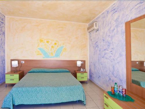 a bedroom with a bed and a painting on the wall at Hotel Ariadimari in Valledoria