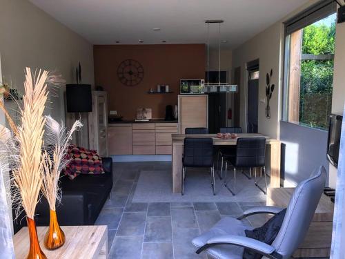 a living room and kitchen with a table and chairs at Jeltje in Wildervank