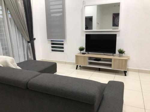 a living room with a couch and a flat screen tv at Baituljannah Homestay Batu Pahat in Batu Pahat