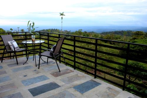 a balcony with a table and chairs and a view at Río Celeste Nature View in Upala