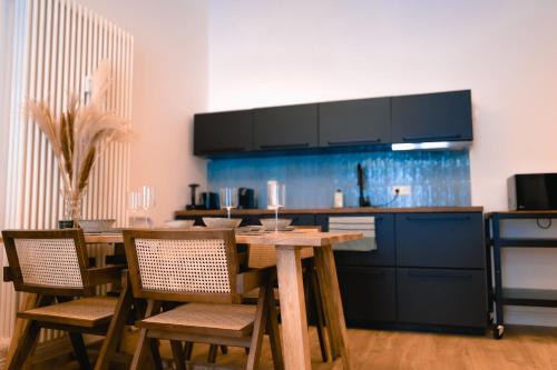 a kitchen with a wooden table with chairs and a counter at The Weinert Suites in Berlin