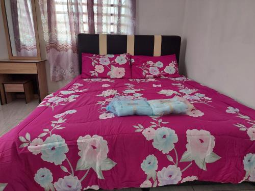a pink bed with pink and white flowers on it at Jerai Geopark Cottage 2 bedrooms Pulau Song² in Yan