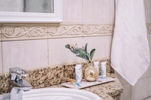Two Continents Holiday Homes - Sea & Palm View Elegant 1 Bedroom Apartment في دبي: منضدة الحمام مع الحوض والمرآة