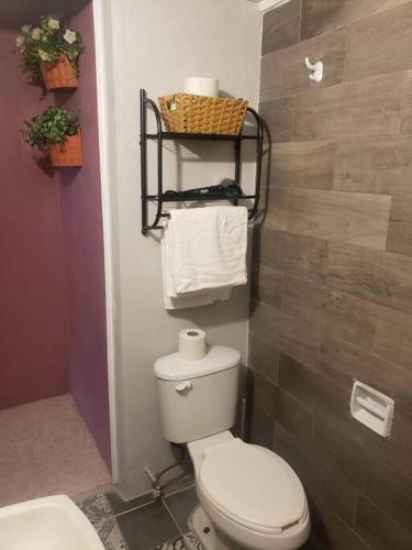 a bathroom with a toilet and a sink and towels at OM Studio in Oaxaca City