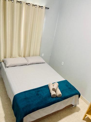 a bedroom with a bed with two towels on it at Portuá Chalés in São Miguel dos Milagres