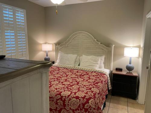 a bedroom with a bed with a red and white bedspread at Cabana's @ Gulf Place #308 in Santa Rosa Beach