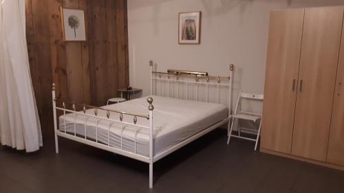 オーステンデにあるSan Marcoの白いベッドと木製キャビネット付きのベッドルーム1室が備わります。