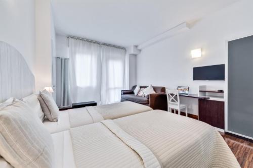 una camera con un grande letto bianco e una scrivania di MARCONI INN a Bologna