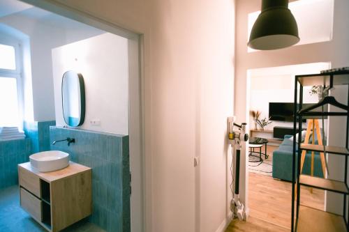 uma casa de banho com um lavatório e um espelho em The Weinert Suites em Berlim