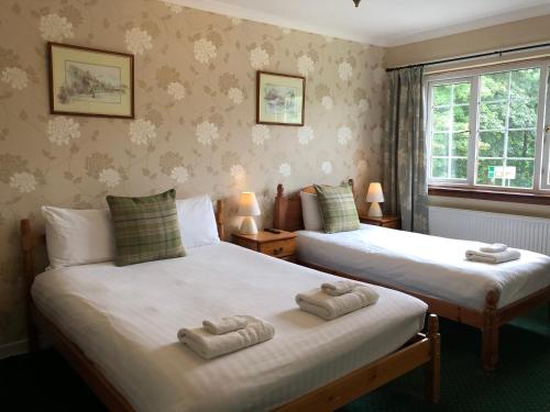 2 łóżka w pokoju z ręcznikami w obiekcie Distillery Guest House w mieście Fort William