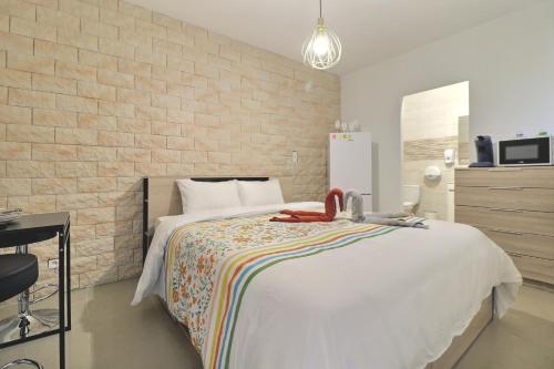 a bedroom with a white bed and a brick wall at Chambre cosy jo in Saint-Alban