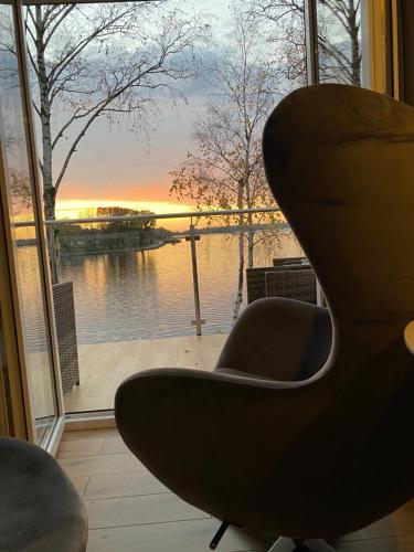 a chair sitting in front of a window with a view at Apartament MoLoo III in Ostróda