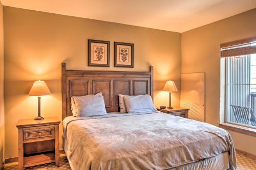 a bedroom with a large bed with two lamps and a window at Cozy Kellogg Condo - Ski at Silver Mountain Resort in Kellogg