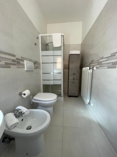 a white bathroom with a toilet and a sink at B & B Piazza Angioina in LʼAquila