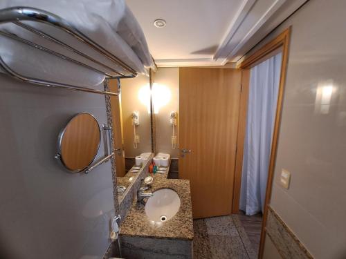 uma casa de banho com um lavatório e um espelho em Flat particular no Lets Idea Brasília em Brasília