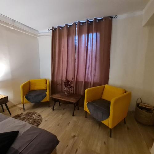 two chairs and a table in a room with a curtain at Het Blauwe Salamander Huis in Kékesd