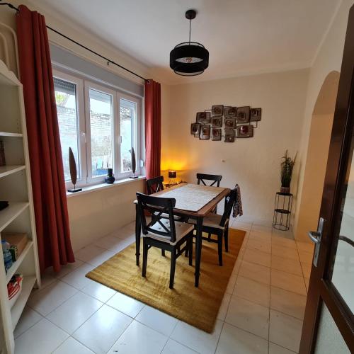 a dining room with a table and chairs and a window at Het Blauwe Salamander Huis in Kékesd
