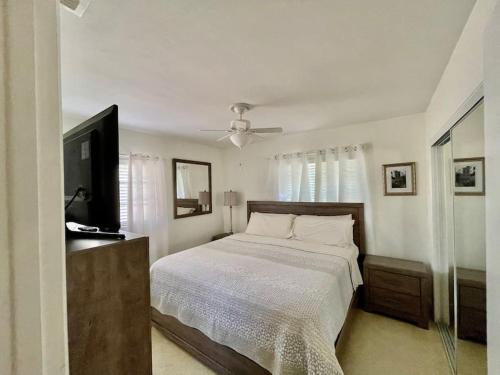 1 dormitorio con 1 cama y TV de pantalla plana en Rowena House 2bd Den 2bth Heated Pool Near Siesta Key, en Sarasota